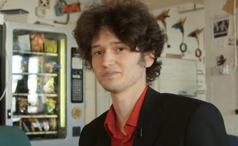 A young mathematician, curly brown hairs, red shirt, black jacket