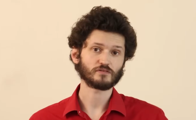 A mathematician 10 years older than in the previous screen capture we took of him, still with curly brown hairs, and still with red shirt, but this time also sporting a beard.